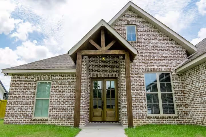 Brick custom home with timber gable entry by a custom home builder in Picayune MS