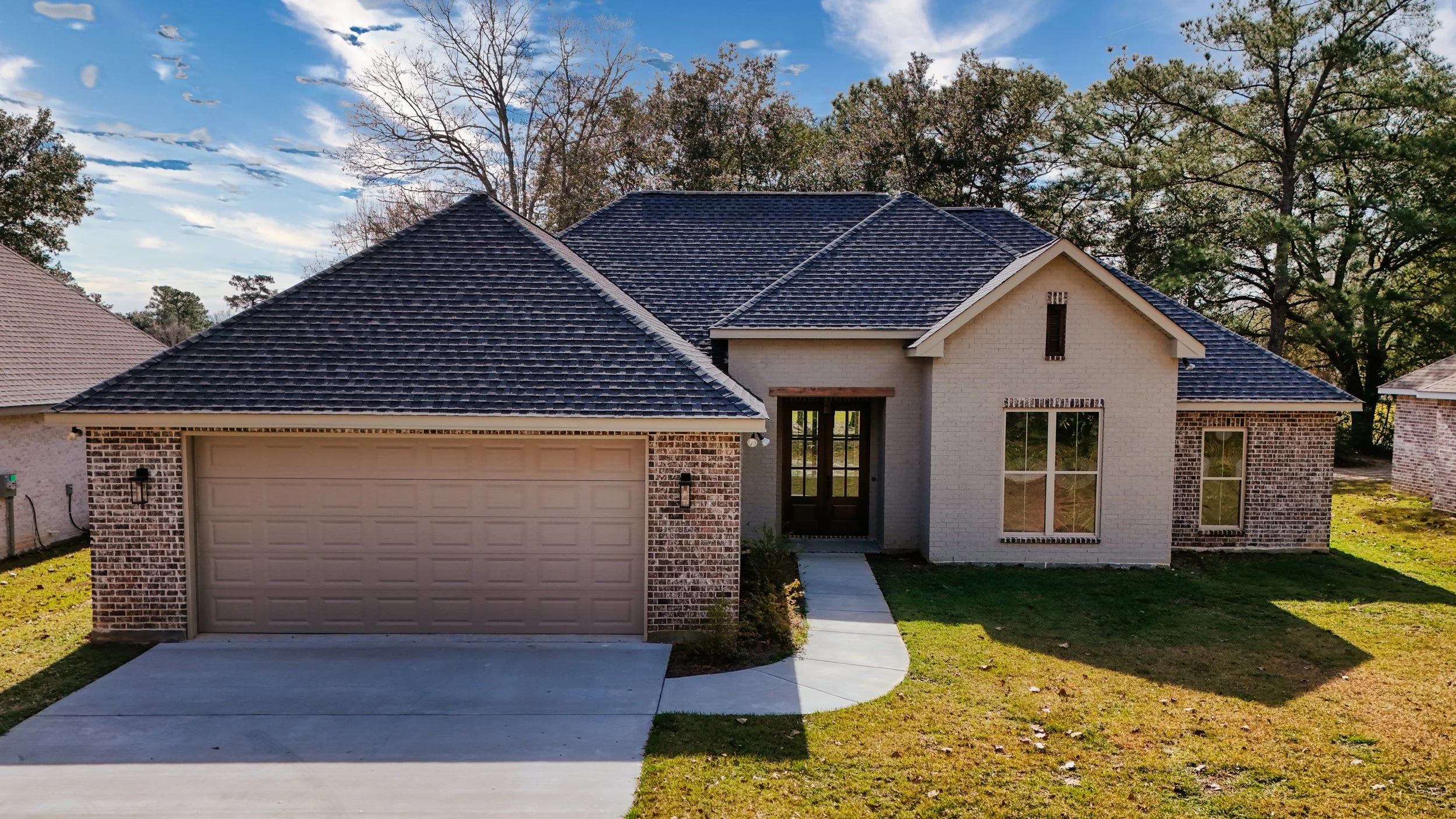 Brick custom home exterior with garage by a home builder in Gulfport MS