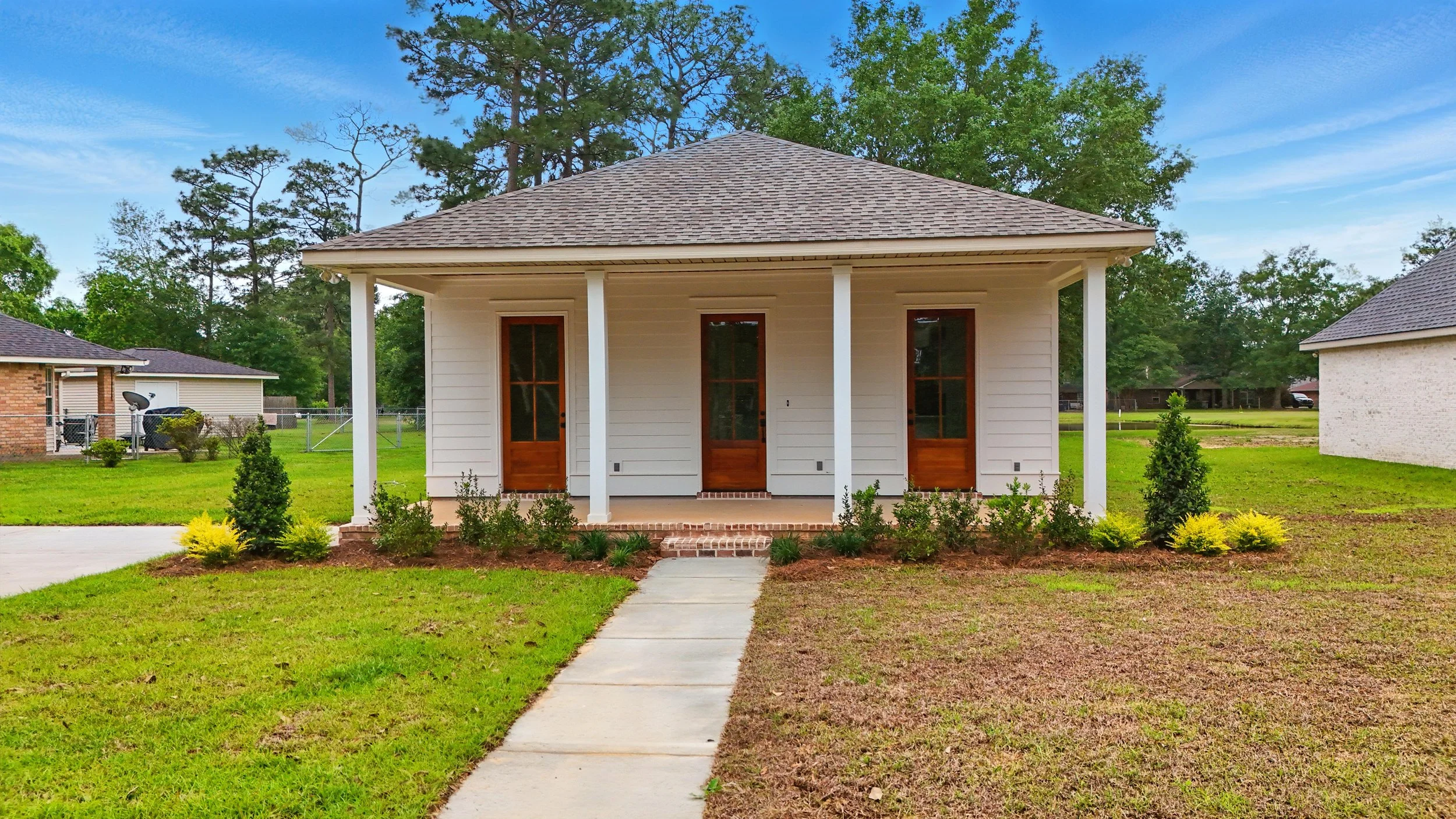 Front exterior of a custom home with covered porch by a home builder in Picayune MS