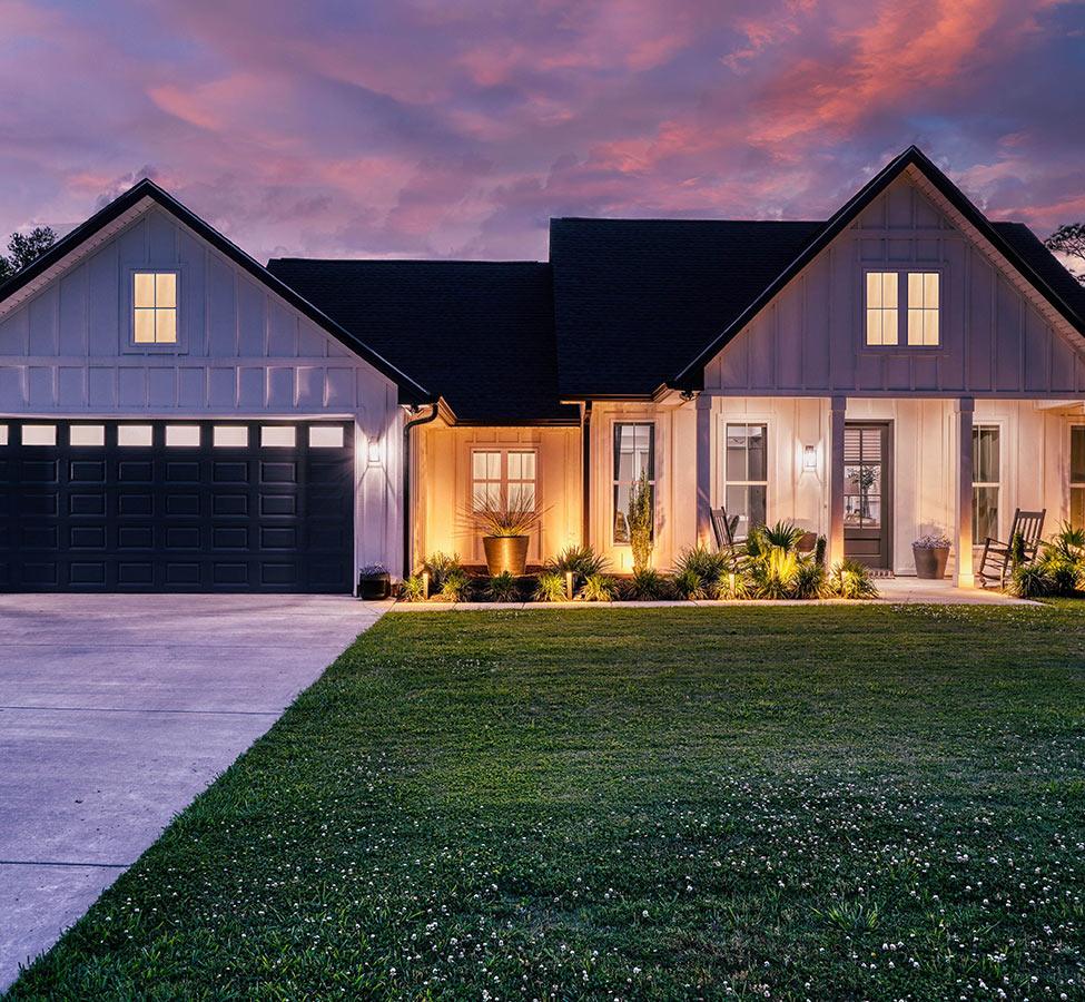 Modern farmhouse custom home at dusk by a home builder in Bay St. Louis MS