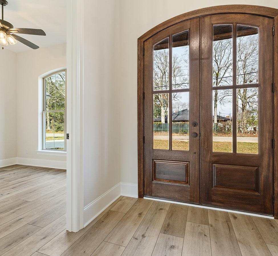 Entry with wood and glass double doors by a custom home builder in Gulfport MS