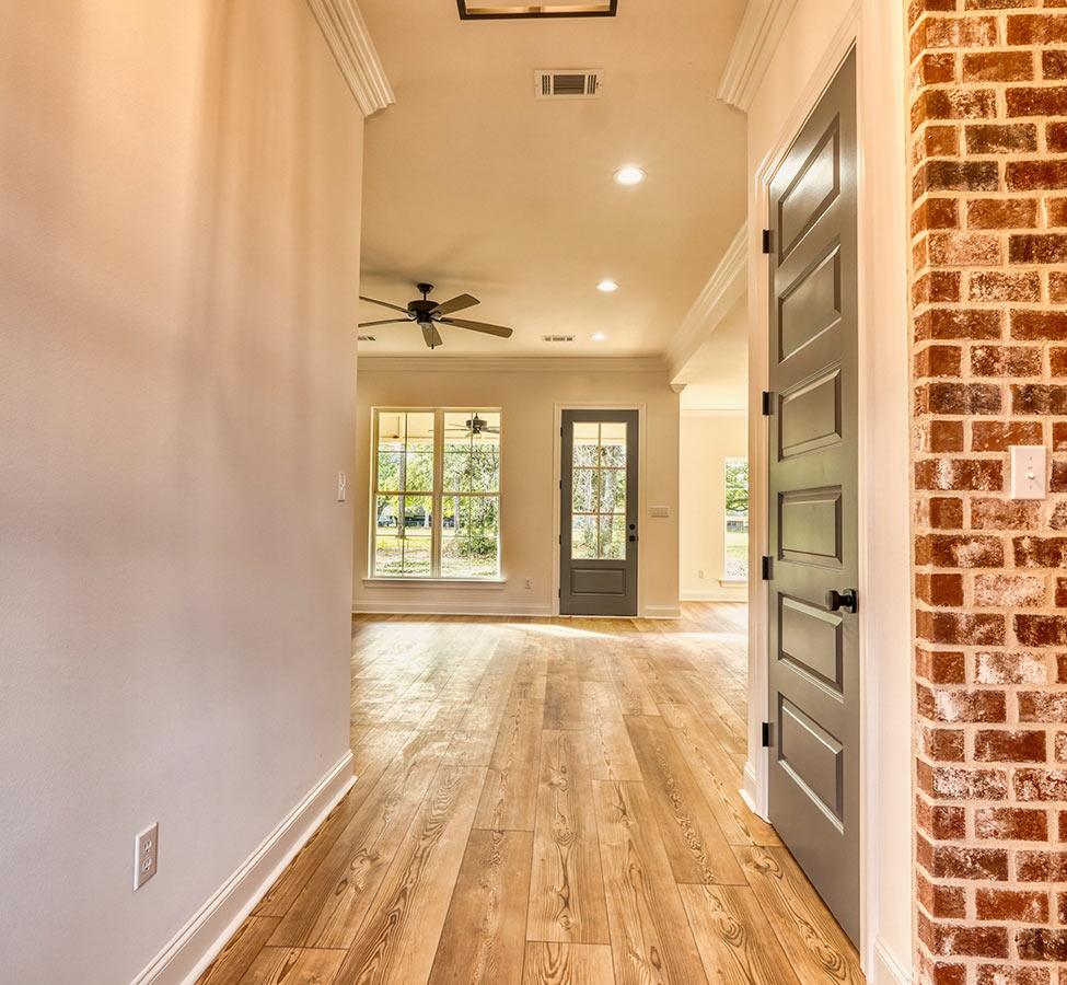 Hallway with brick accent wall in a custom home by a home builder in Pass Christian MS
