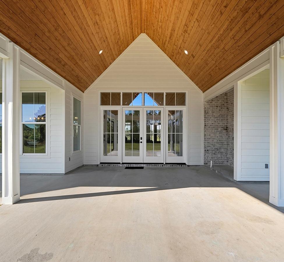 Living room with vaulted ceiling and French doors by a custom home builder in Picayune MS