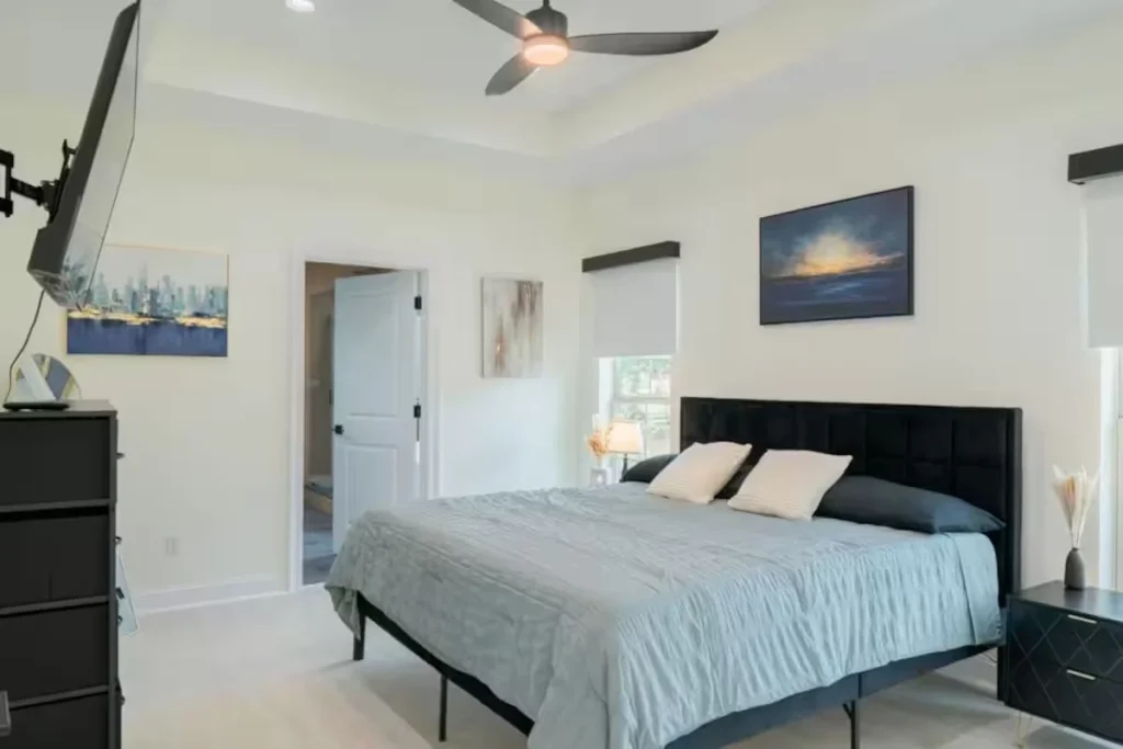 Bedroom with upholstered bed in a custom home by a home builder in Picayune MS
