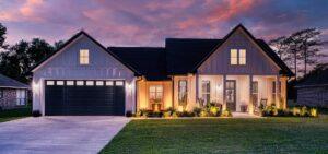 Modern farmhouse custom home at dusk by a custom home builder in Waveland MS