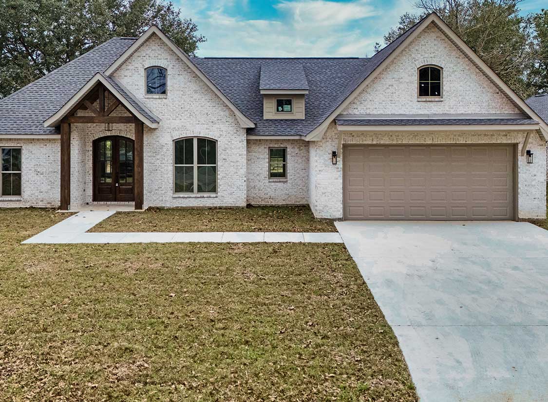 Brick custom home exterior with garage by a custom home builder in Picayune MS