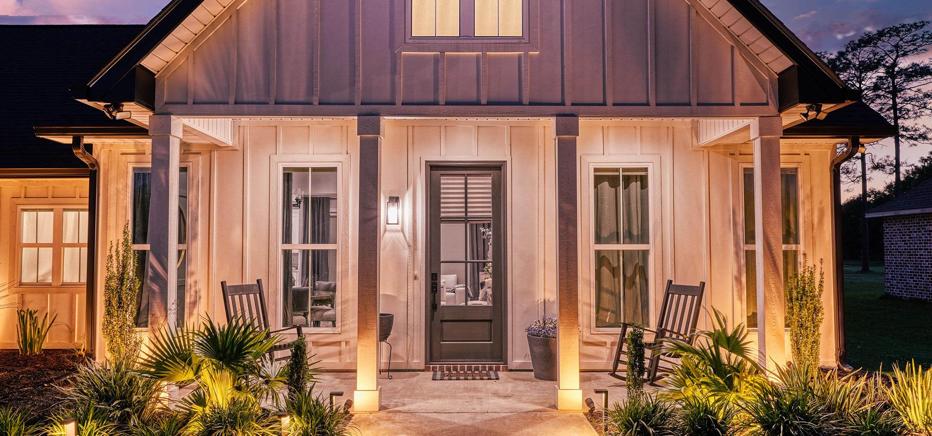 Modern farmhouse custom home porch at dusk by a custom home builder in Picayune MS