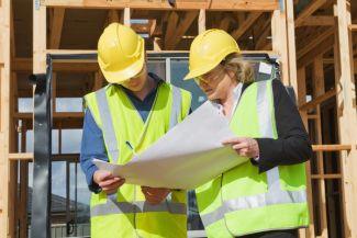 Two workers reviewing the design build for a custom home in Kiln, MS